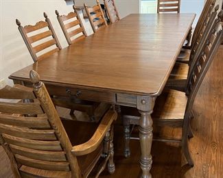 Solid wood dining table and 10 chairs. Extends to 9 feet with 2 leaves.