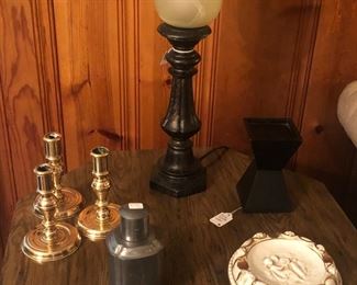 End table with doors to underneath storage.  Three brass candle holders.  Pewter container with lid.  Black candle holder for pillar candle.  Ashtray
