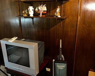 one of the TVs, end table,  Liberty Hoover vac and some of the many  knick knacks