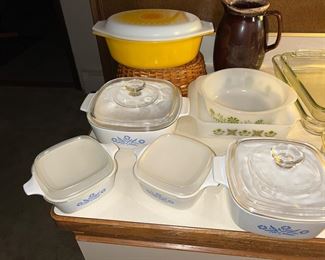 In the back, the Pyrex yellow/orange Daisy Sunflower casserole dish with wicker basket and you’ve got various corning ware pieces.