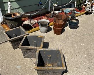 Various plant holders and the four post chain link white fence plastic And shepherd hooks in the back.