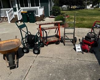 On the left- a very good/sturdy wheelbarrow, a four wheel hose caddy, a two way two wheel/four wheeled dolly, two very sturdy break down sawhorses, truly an old vintage two wheel dolly, ON the RIGHT - Genera 1300 psi and behind the 2300 psi is a larger Generac four-wheel pressure washer.
