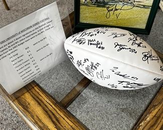 Take a look at the sheet on the left side and you’ll see some of the 36 autographs on the 2003 University of Wisconsin football team! Behind the the badger football is a signed action picture of Brett Favre with the COA inside the frame.