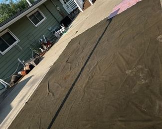 A very heavy duty ~ 21’ x ~15’ tarp with reinforced grommets. This could’ve been used for the top cover of a carport. Note in the upper right hand corner is a regular size moving van blanket.

