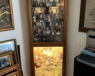 This corner display cabinet is an unusual piece, but perfect for smaller collections.  See the stack of framed artwork, on the left side.  Oh, and the hint of a typewriter on the right.
