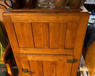 The primary item shown here is a vintage ice box, with mugs or steins on top.