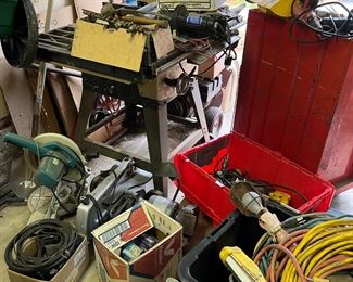 In addition to the scroll saw, compound miter saw, and table saw, there is also a motorized grinder, belt sander, and heat gun.