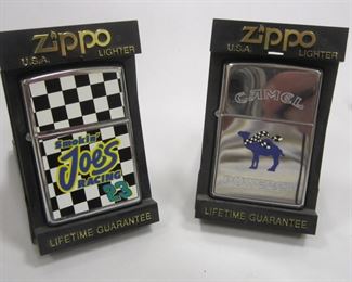 TWO CAMEL ZIPPO LIGHTERS IN DISPLAY CASES: CAMEL POWERED AND SMOKIN JOE'S RACING 23. BOTH ARE SEALED. 1990'S