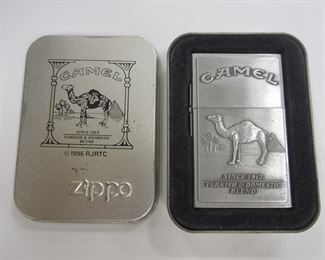 TWO CAMEL ZIPPO LIGHTERS IN DISPLAY CASES: CAMEL POWERED AND SMOKIN JOE'S RACING 23. BOTH ARE SEALED. 1990'S