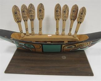 NORTHWEST COASTAL CARVED WOOD CANOE AND PADDLES. CANOE IS 22.75" LONG. ONE PADDLE IS SPLIT, CHIP ON ONE EDGE OF CANOE. ALL CEDAR