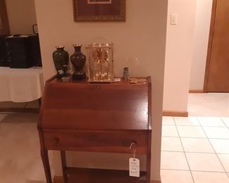 Petite slant top desk as you enter the main floor living room.  Clock, cloisonne vases, and carved stone flowers.