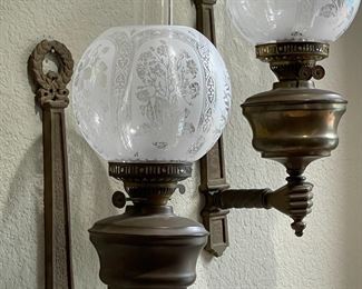 Wall sconce, double wicked oil lamps.  Love those hands!