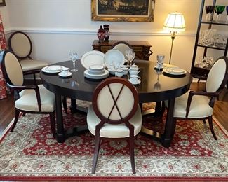 Barbara Barry for Baker Furniture Dining Table with X-Back Dining Chairs 
Oval Dining Table 
108” Width
48” Depth
29 3/4” Height 
Including Two 20" leaves and Protective Padding
The dimensions for the oval X-back dining Captain Chairs with Arms are…
27" Width
19 1/2" Depth
18” Seat Height 
38 1/2" Back Height
The oval X-back side chair dimensions are…
23" Wide
24" Depth
18” Seat Height 
38 1/2" Back Height
Magnificent signature design by Barbara Barry. Barbara Barry intends for her furniture designs to connect people to the splendor of the natural world around them. Barry’s admiration for organic materials and the subdued color palettes make her furniture designs timeless! Simple and calming, her furniture is quietly elegant and has garnered Barry renown worldwide as a leader in interior design. Barry has created exclusive furniture collections and home decor for other legendary brands as well…