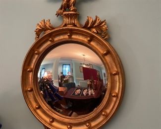 This mirror is parabolically shaped instead of flattened. Crafted in Italy . Hand Carved golden wood frame embellished with an eagle . 21” x 33” Tall. 
