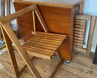 Wooden drop leaf table with 4 folding wooden chairs that store under the table.