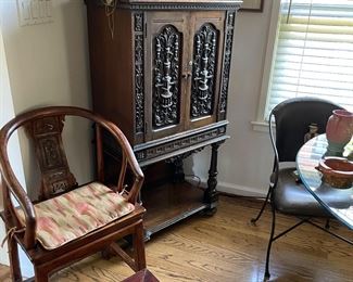 Another view of the Asian wood armchair and stool,   carved storage chest, and  martinet puppets 