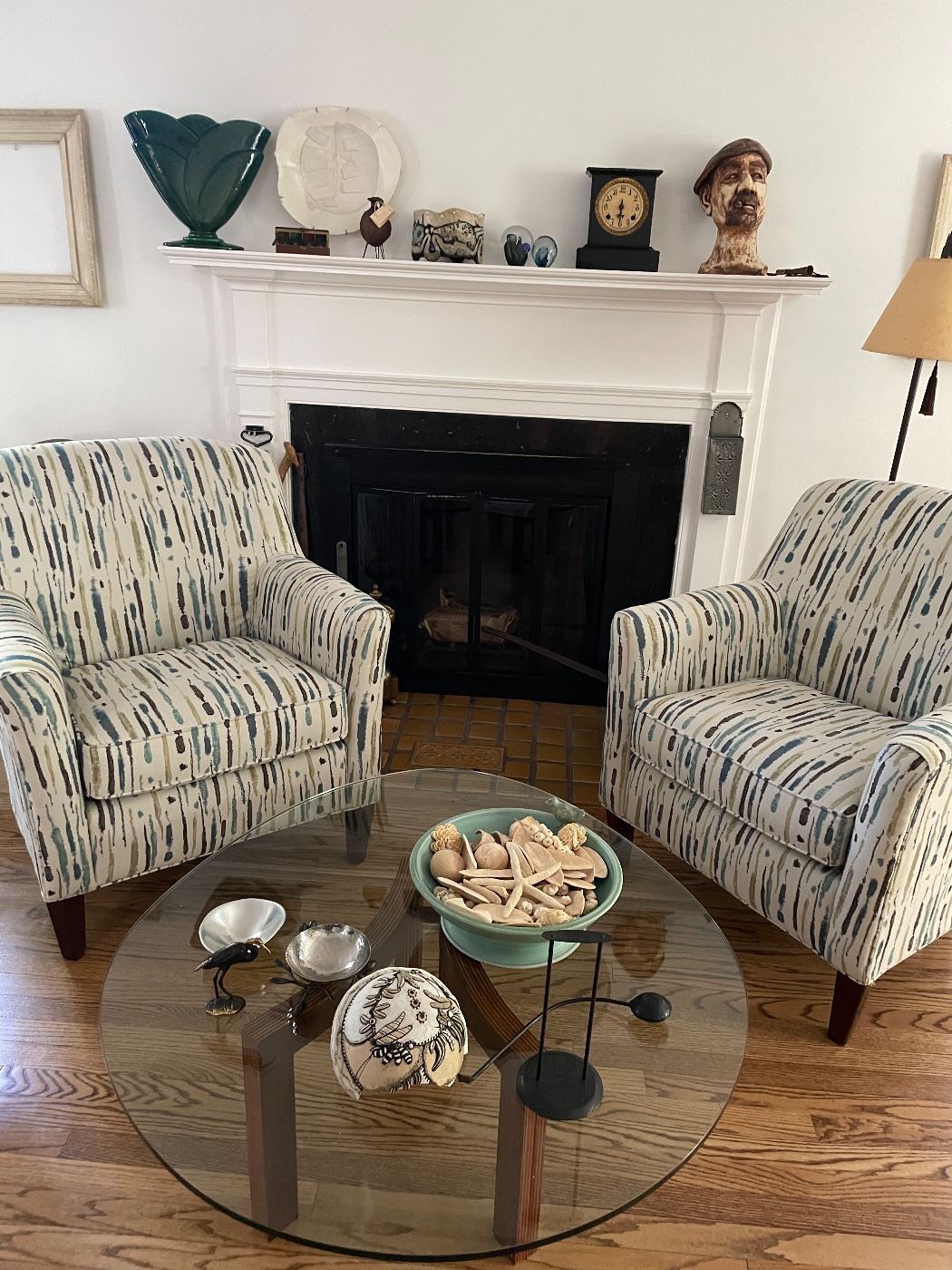 Pair of armchairs, round glass cocktail table with wood base, pottery and collections