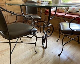 Another view of the metal and glass dining table with leather and metal chairs