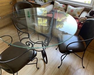 Another view of the round glass table with metal base and 3 metal and leather dining chairs