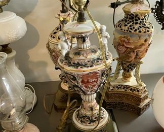 A pair of vintage Capodimonte Putti hand painted lamps, old pictures and lamps will be set up with their shades, if I have the harps plus shades for them. Mom had some stored in closet, so had to add them for sale.