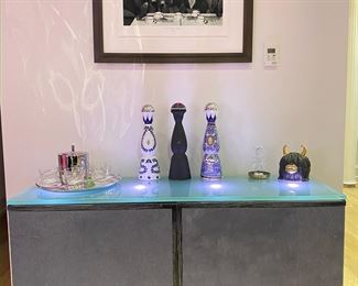 Side Board, Custom! Great condition. This custom made credenza can be used as a bar. Interior storage draws and adjustable up lights in the glass that can be turned on and off. Gray pony hair doors, with black wood trim, Silver metal Legs with matte finish, Frosted glass top with built in up-lights that accent anything that's sitting on top. W54" D18" H34"