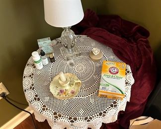 Round table, and table cloth; doily; essential oils; lamp