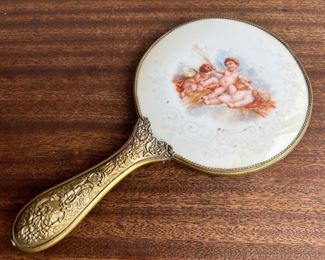 Victorian Cherub Motif Painted Porcelain Backed Hand Mirror With Repousse Brass Handle 