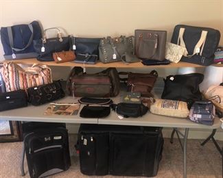 Table full of ladies purses & bags & wallets