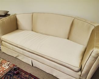 Mid-Century Sofa with Off-White and tiny figuring on the fabric.  It has not spots or frayed edges.  The arms are as tall as the back which swells to the highest point of the sofa.  Pleated front and cording added for style.