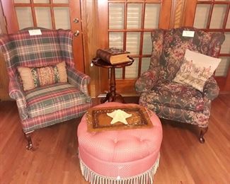 Vintage upholstered wingback chairs, ottoman, scalloped edge small table, antique pictorial Bible, and a hammered copper tray.