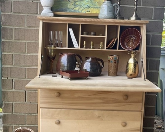 Unfinished slant top desk with lots of cubbies and drawers, a variety of baskets, and home decor.  