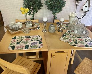 Perfect table and chair set for small space.  Chairs are stored in center cabinet.  Plus large assortment of decorative table top items.