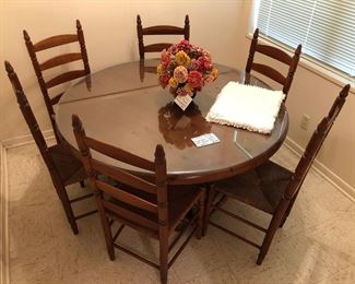 Solid wood 53” round pedestal table
Six cherry ladder-back chairs
Six placemats
Silk flower arrangement
