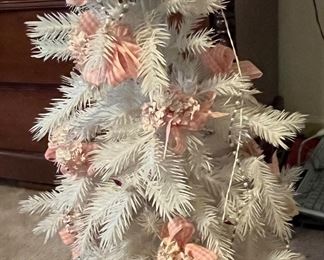 Vintage white plastic Christmas tree with pink plastic bows and decor.