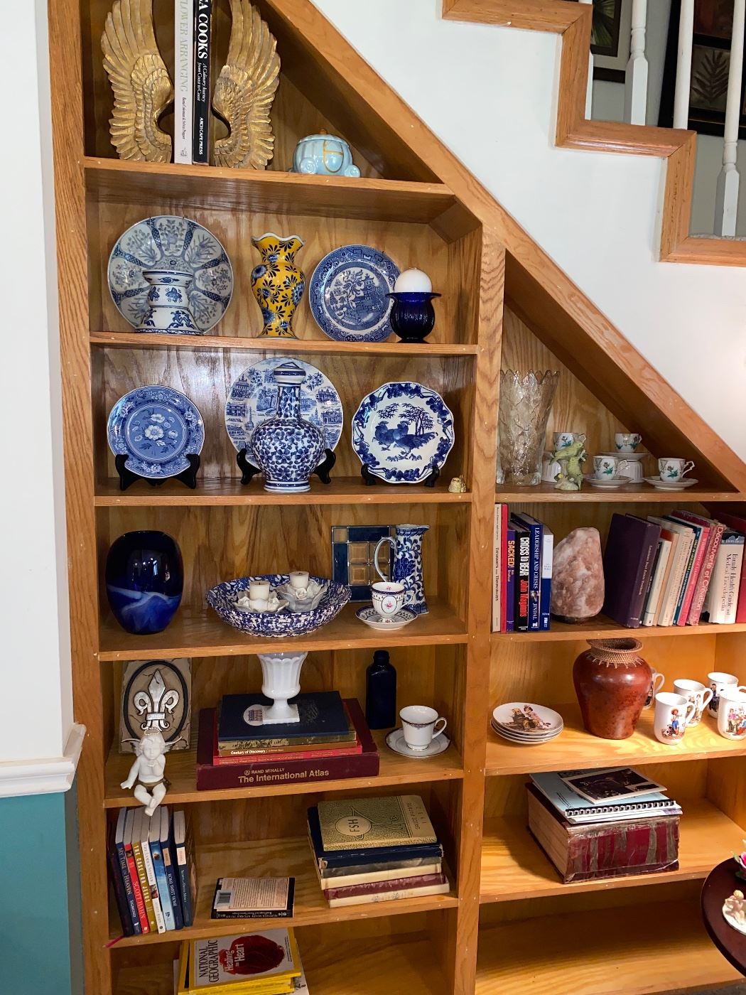 This cool under the stairs bookshelf is loaded with nice decor