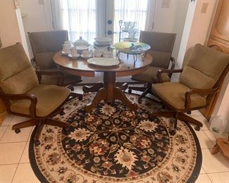 Round  breakfast table with one leaf and four rolling chairs. Shown with leaf in place making it oval