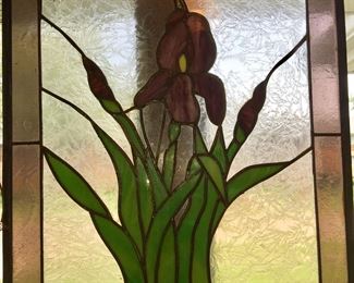 An iris stands tall and pretty in this stained glass interpretation of a garden staple. 