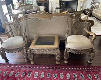 Two Hand and earn chairs in solid wood frame and gold finish and microfiber seat cushions and matching end table in gold finish wood frame and beveled glass top 