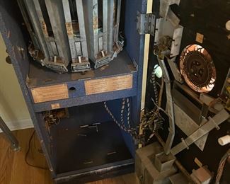 1957 Genco Horoscope, Fortune Teller machine. Works great!
-Measures 80" Tall, 22" Deep and 23" Wide. Includes Keys!
Description: A dime for the horoscope and a nickel for the fortune. When you a nickel or a dime, the Genco Horoscope Grandma moves her head, moves both hands, and breathes. The hoppers inside rotates until the right scroll horoscope is delivered into the tray out front. There are thirteen different drawers, one for each of the twelve month horoscope rolls, and a 13th drawer for the fortune roll. The horoscopes and fortunes are rolled up into small plastic tubes. If a nickel is inserted a fortune is dispensed. If a dime is inserted, the user selected horoscope (or fortune!) is dispensed. Many Genco Horoscope Grandmas have a modification - if a fortune only is requested, grandma again moves and the glowing ball lights up "yes" or "no" for the fortune.