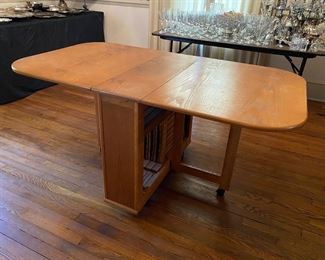 F13 - $50. Drop leaf table on wheels that stores 4 folding chairs inside. Measures 10.25" wide with leaves down. 34" long x 29.5" tall. Each leaf adds 25.5" (61" long with leaves up)