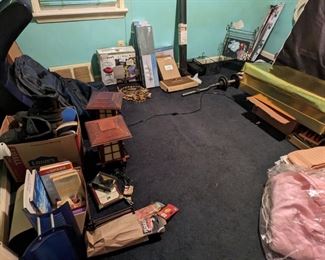 Room with assorted items. Vintage wedding dress, bed and box spring, lamps