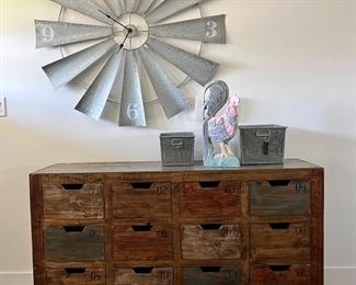 Love this rustic cubby cabinet with industrial wheels and the Windmill clock!