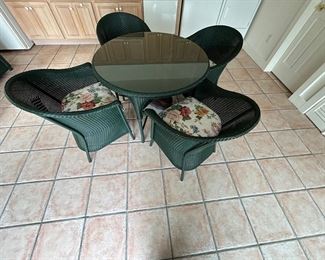 SLIGHTLY USED CONDITION GREEN WICKER CIRCULAR TABLE WITH FOUR CHAIRS- DESIGNER CUSHIONS