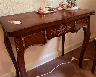 In the powder room, a spectacular vintage French parquetry, inlay flat top game table with ormolu mounts