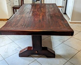 "SLEEPER-WOOD" BURMESE TEAK DINING TABLE
● In the 1800’s the British brought railroad transportation to southern Africa. But because of a lack of reliable local timber, they imported much of the wood needed for the railroad ties from
British colonies elsewhere. 
● By the 1990's, these railroad ties (British call them “Sleepers”) finally began being replaced by concrete sleepers.
● Local furniture artisans bought huge piles of these old sleepers as they were made from ancient tropical hardwoods - Teak from Burma being one of the most
prized. The rustic furniture made from the railroads thus became locally known as Sleeper Wood Furniture.
● Having survived 150 years underground in Africa with borer-beetles gnawing at them and steam locomotives dropping coal on them, these pieces were custom-made for a South African immigrant to the US. None of this furniture has ever seen urethane, polish or stain on them. The wood oils protect it naturally, but an occasional wipe with mineral oil (o