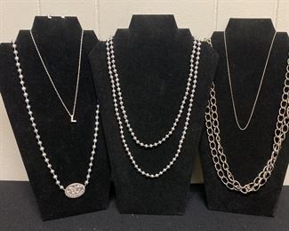 Five Silver Colored Necklaces and One Pair of Earrings