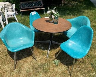Chromcraft Fiberglass Shell Chairs, two with arms and two without, 
Turquoise; 4 in total. No cracks 
Herman Miller Mini-Round Conference Table, 36-inch with Wood Grain Laminate Top - has original Herman Miller Sticker on underside of table, designed by Charles Eames.  