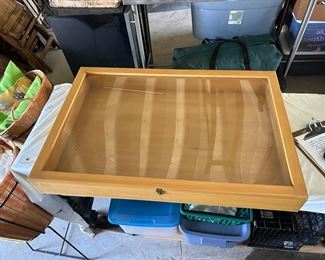 Wooden display case with hinged glass front door.                                      36" W x 24" L x 4.5" D                                                                                                  $45