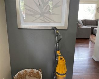 Dyson vacuum, wicker basket, wall art