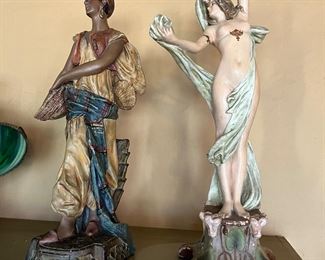 Polychrome terracotta Orientalist sculpture by Uriela of Cologne Germany, circa late 19th century (potentially 1880s or 1890s), in the style of Goldsheider. 
On the right, C. Hennecke Co plaster statue figurine of a nude woman. 